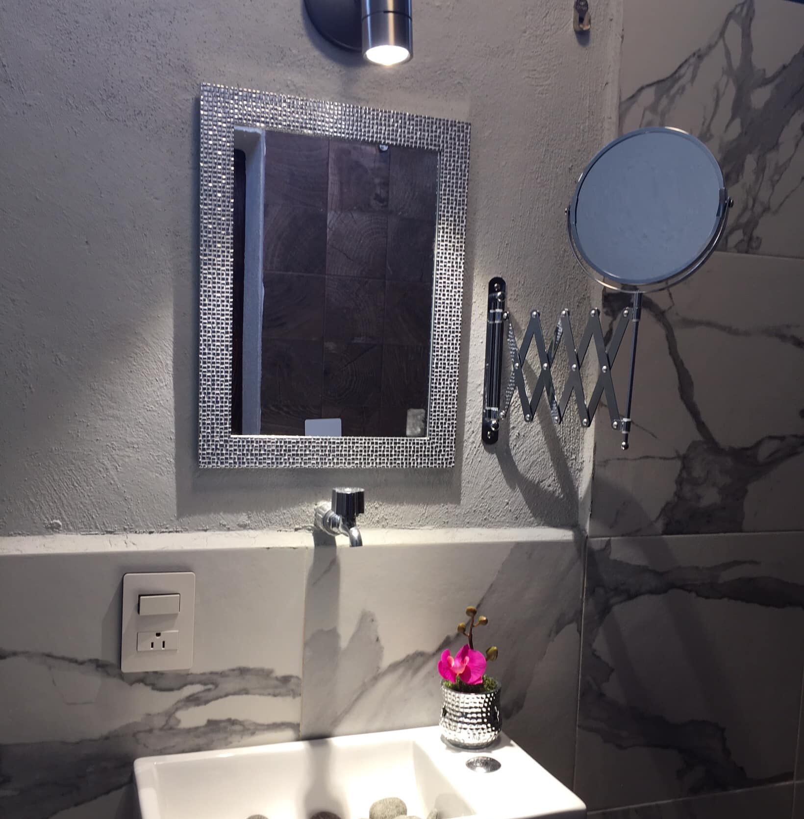 A bathroom with a white sink, a mirror, and a towel rack.