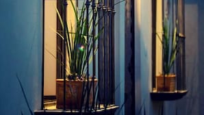 A building with a balcony, a potted plant, and a wall-mounted light fixture. - Equinoccio Peña de Bernal (Ezequiel Montes)