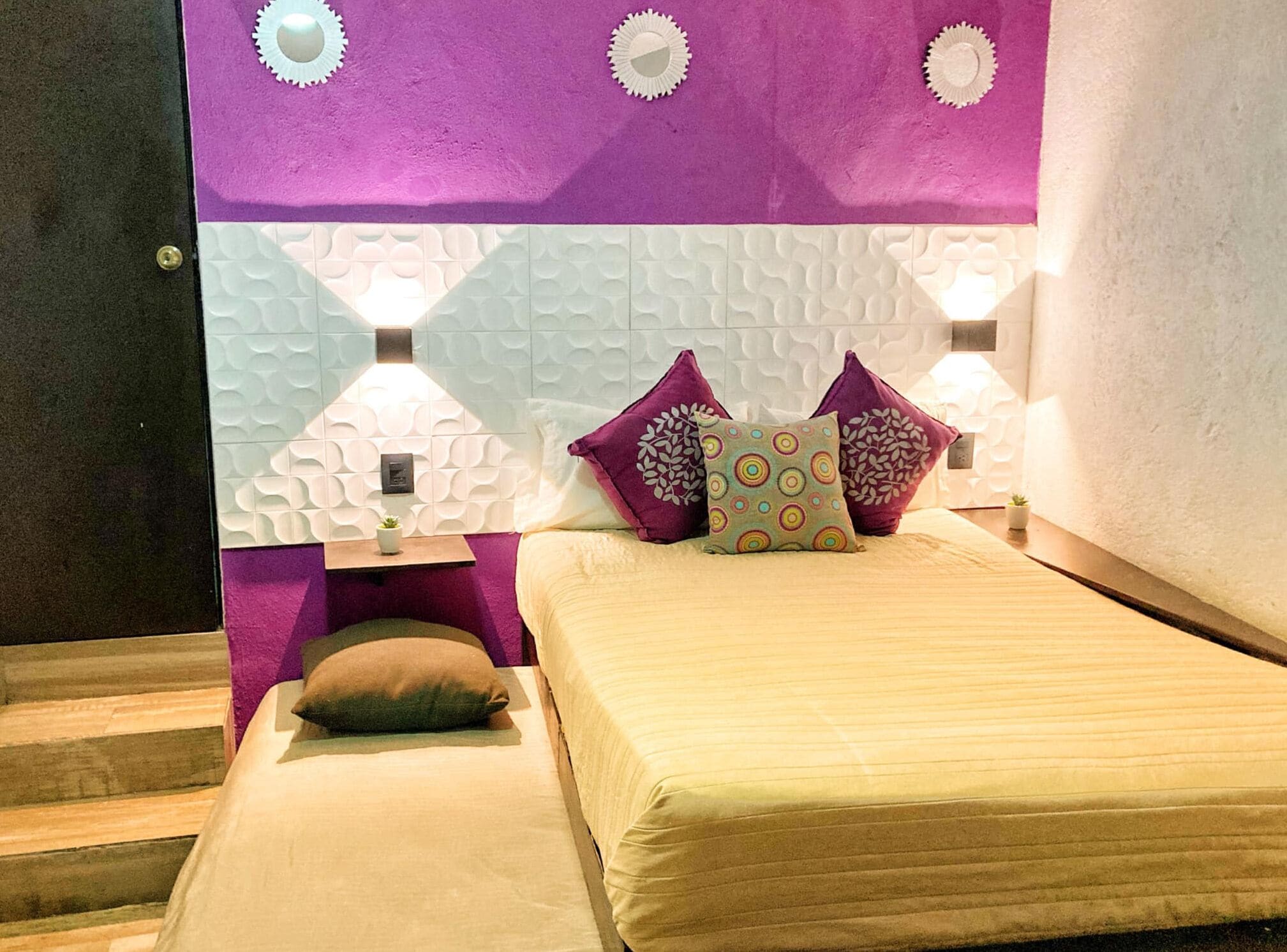 Une chambre à coucher comprenant un lit, deux tables de chevet et un mur agrémenté d’éléments décoratifs.