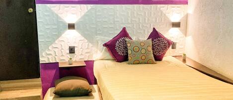 Une chambre à coucher comprenant un lit, deux tables de chevet et un mur agrémenté d’éléments décoratifs.