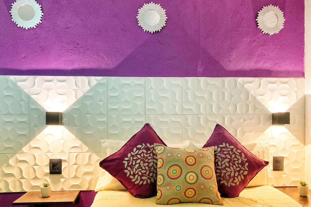 A room with a bed, two nightstands, and decorative wall panels.