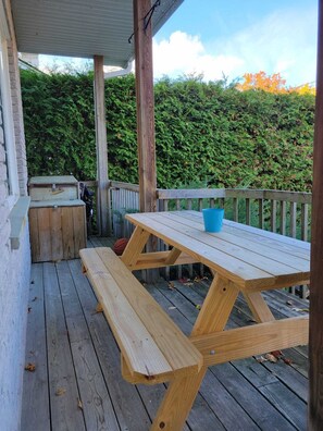 Enjoy al fresco dining on the deck, surrounded by lush foliage and a brick wall.