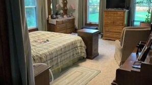 A bedroom with a bed, dresser, TV, and a ceiling fan. - Oak Meadow Farmhouse (Spring Valley)