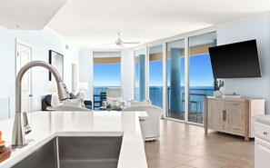 A modern hotel room with a balcony, a large flat-screen TV, and a dining area with a view of the ocean. - Palazzo 1708 (Panama City)