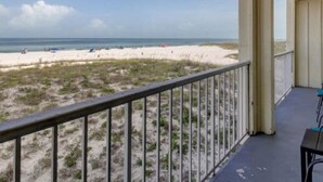 A balcony with a view of a beach and ocean.
