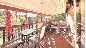 Eine überdachte Terrasse mit Holzmöbeln und Geländer.