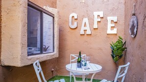 A cozy cafe corner with a small round table, white chairs, a bottle of champagne, and two glasses. - Private condo near Mayo Clinic with garage, patio, office, and pool access.  (Scottsdale)