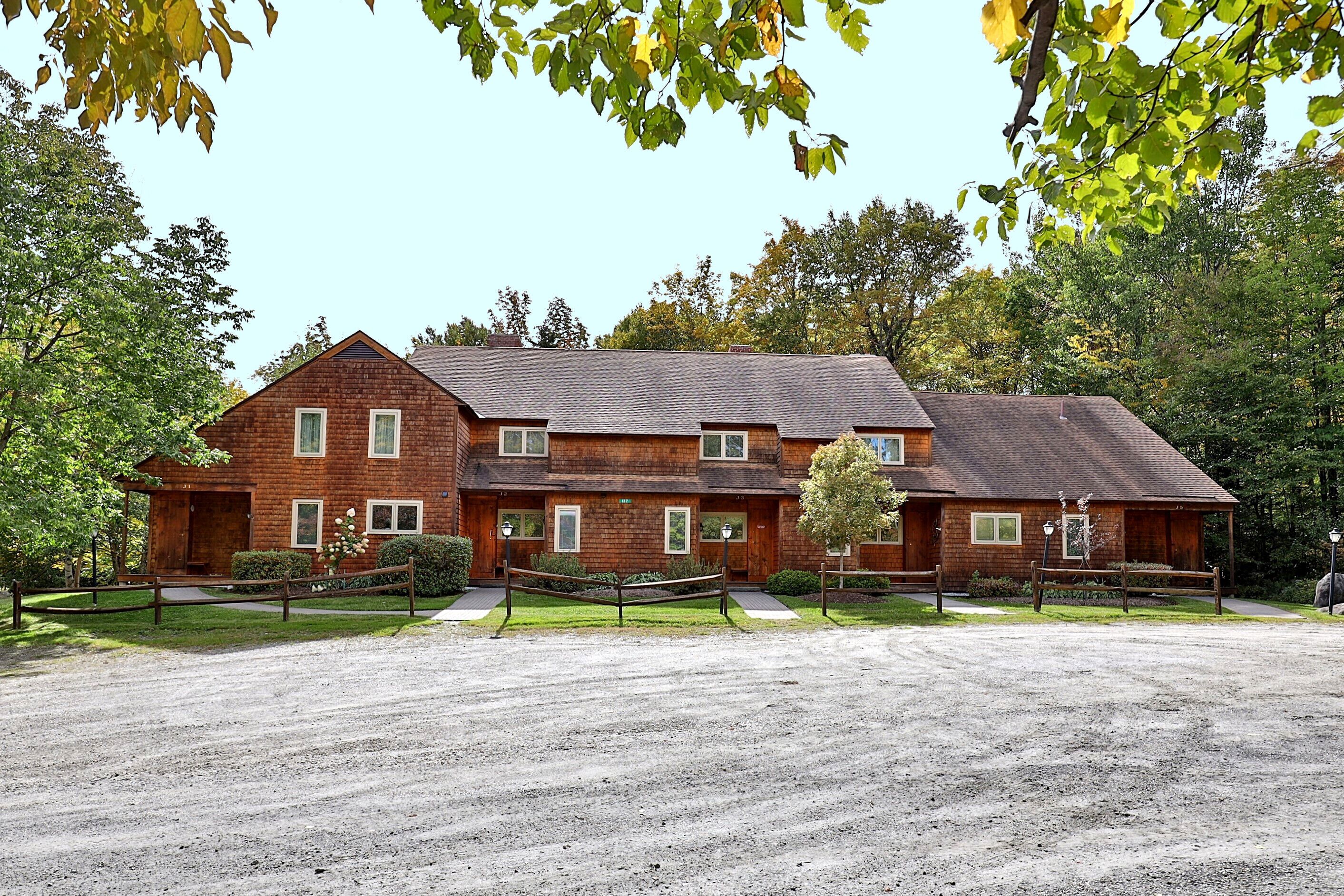 A large brick building with multiple windows and a covered porch area.
