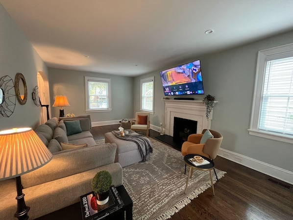 Una sala de estar con chimenea, televisor y sofá.