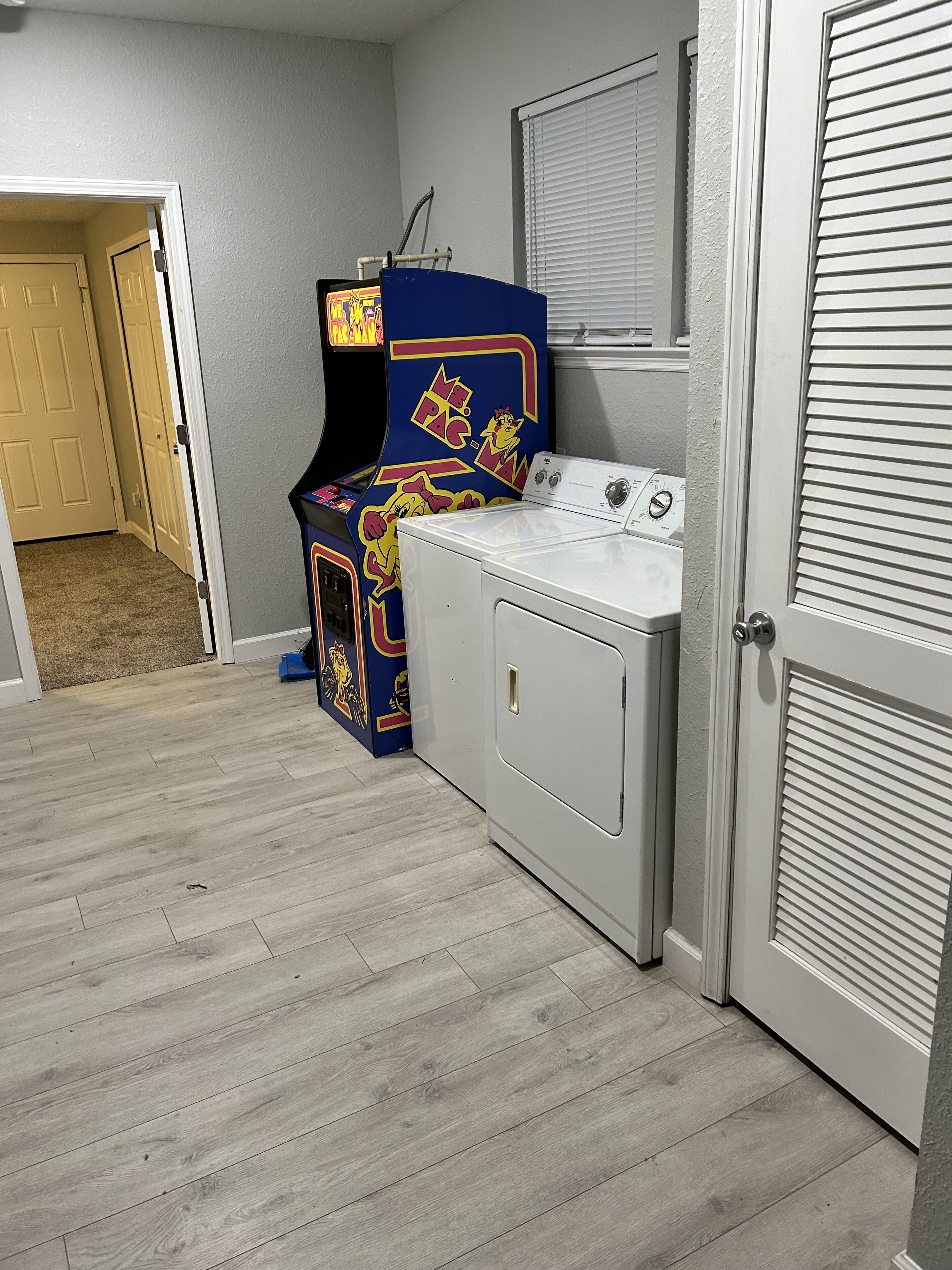 Un cuarto de lavandería con lavadora y secadora, una puerta y un calentador instalado en la pared.