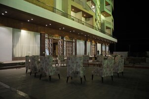 Un vestíbulo de hotel con una zona de estar y una escalera que conduce a los pisos superiores.