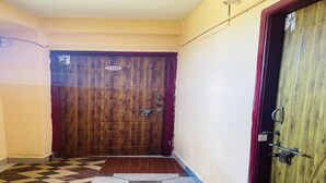 Un pasillo con una puerta de madera marcada con el número 108 y una reja de metal.