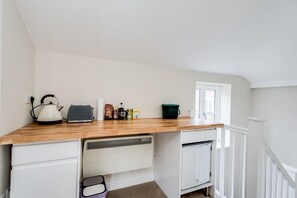 A compact kitchenette with a wooden countertop, a kettle, a toaster, and various food items. - The Mews - 1BR Studio in Jericho Near City Centre (Oxford)