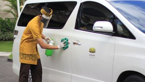 A person cleaning a white van with a logo and text on the side. - 2 BR Villa in Seminyak, 25sqm Private Pool, 5 mnts walk to shopping area (Bali)