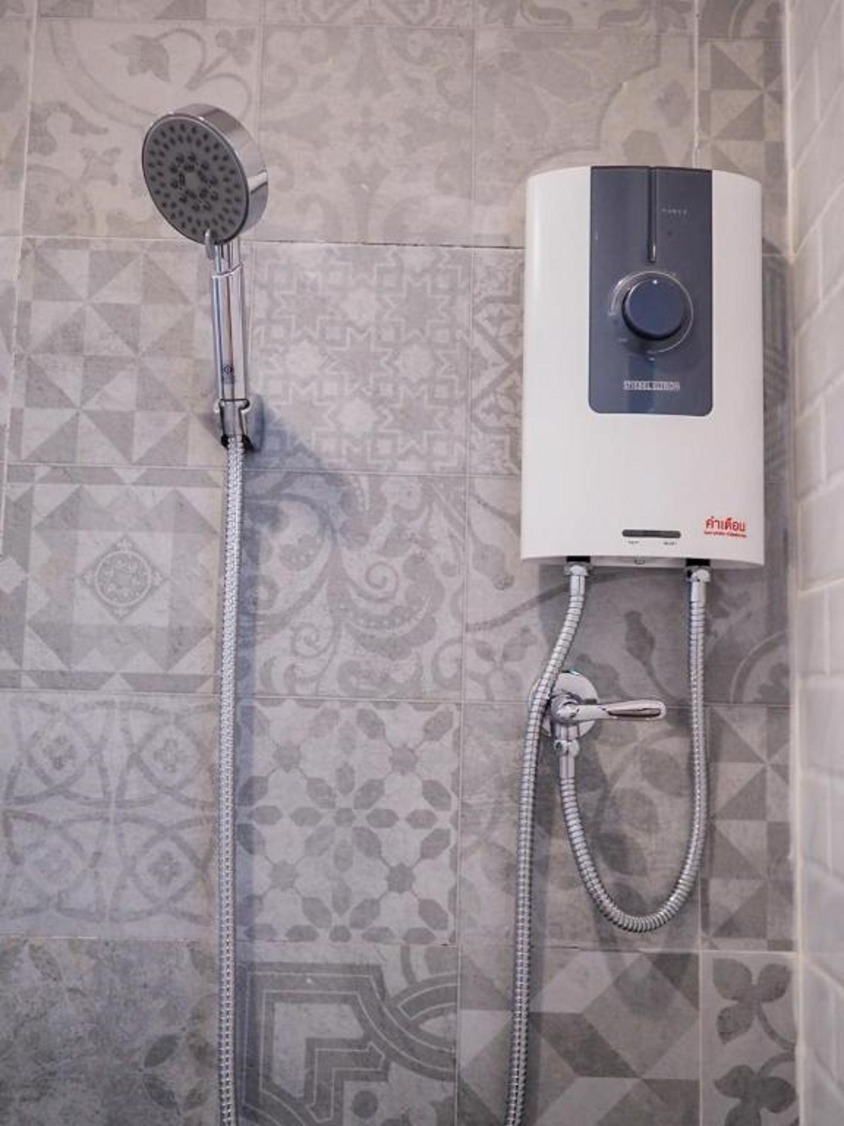Una ducha con panel de control y cabezal de ducha de mano, conectada por una manguera flexible.