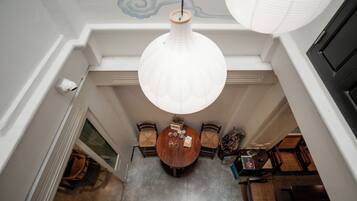 A dining area with a round table, chairs, and hanging paper lanterns.