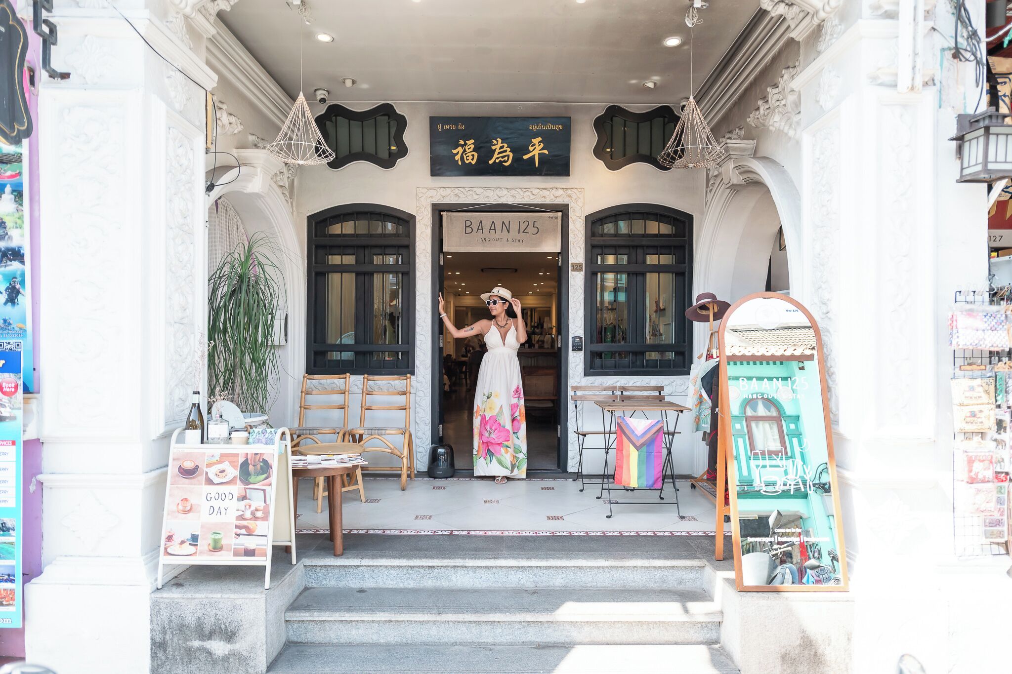 A boutique hotel entrance with a signboard, a staircase, and a display table with items.