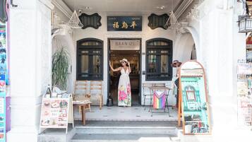 A boutique hotel entrance with a signboard, a staircase, and a display table with items.