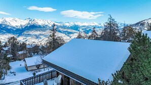 Un paysage montagneux enneigé avec une cabane et une terrasse en bois.