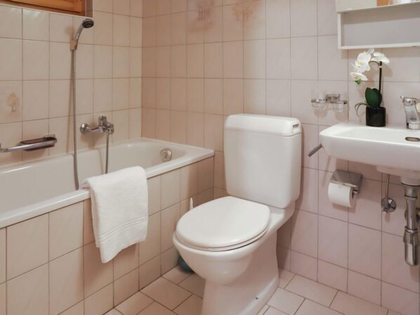 Ein Badezimmer mit Toilette, Badewanne und Waschbecken.