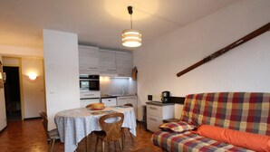 Un espacio habitable pequeño con zona de comedor, un sofá y una mesa de centro.