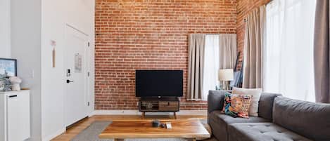 Spacious living room with ample seating for the group, a smart TV and beautiful downtown views
