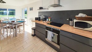 A modern kitchen with a wooden countertop, a built-in oven, and a microwave. - 3 bedroom stunning home in Trévou-Tréguignec (Trévou-Tréguignec)