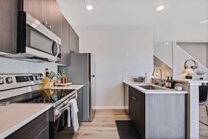 A modern kitchen with a built-in oven, microwave, and refrigerator. - Stylish 2 bedroom townhome (Nampa)