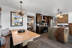 A modern kitchen with wooden cabinets, a central island, and pendant lighting. - Rocky Mountain Gem!  Fireplace and Private Jacuzzi, Two Large patios, (Estes Park)