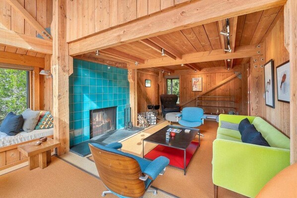 A wooden interior with a fireplace, seating area, and a staircase. - Binker Barn Reimagined | Sea Ranch Art (Sea Ranch)