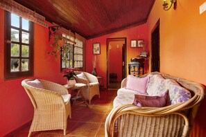 A room with wicker furniture, a door, and a window.