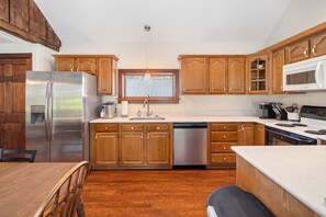 A modern kitchen with wooden cabinets, stainless steel appliances, and a dishwasher.