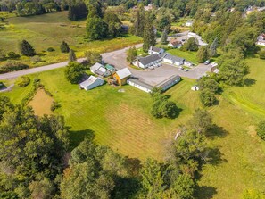 An aerial view of a rural property with multiple buildings, including a large barn and residential houses.
