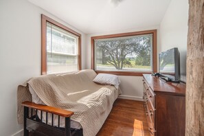 Un dormitorio con cama, cómoda y televisión.