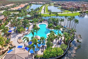 A resort with a central swimming pool surrounded by palm trees and lounge areas. - First Floor Corner Unit Condo On a Coveted Quad in Paseo of Fort Myers (Fort Myers)