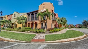 A row of multi-story buildings with balconies and a central courtyard. - First Floor Corner Unit Condo On a Coveted Quad in Paseo of Fort Myers (Fort Myers)