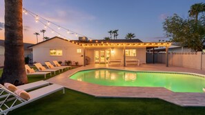 A backyard with a swimming pool, lounge chairs, and string lights. - Tempe Oasis with Heated Pool and 4 Kings (Tempe)