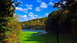 Un parcours de golf avec un lac, entouré d’arbres aux feuilles d’automne.