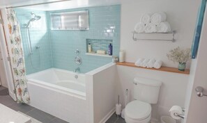 Ein Badezimmer mit Badewanne, Toilette und Dusche.