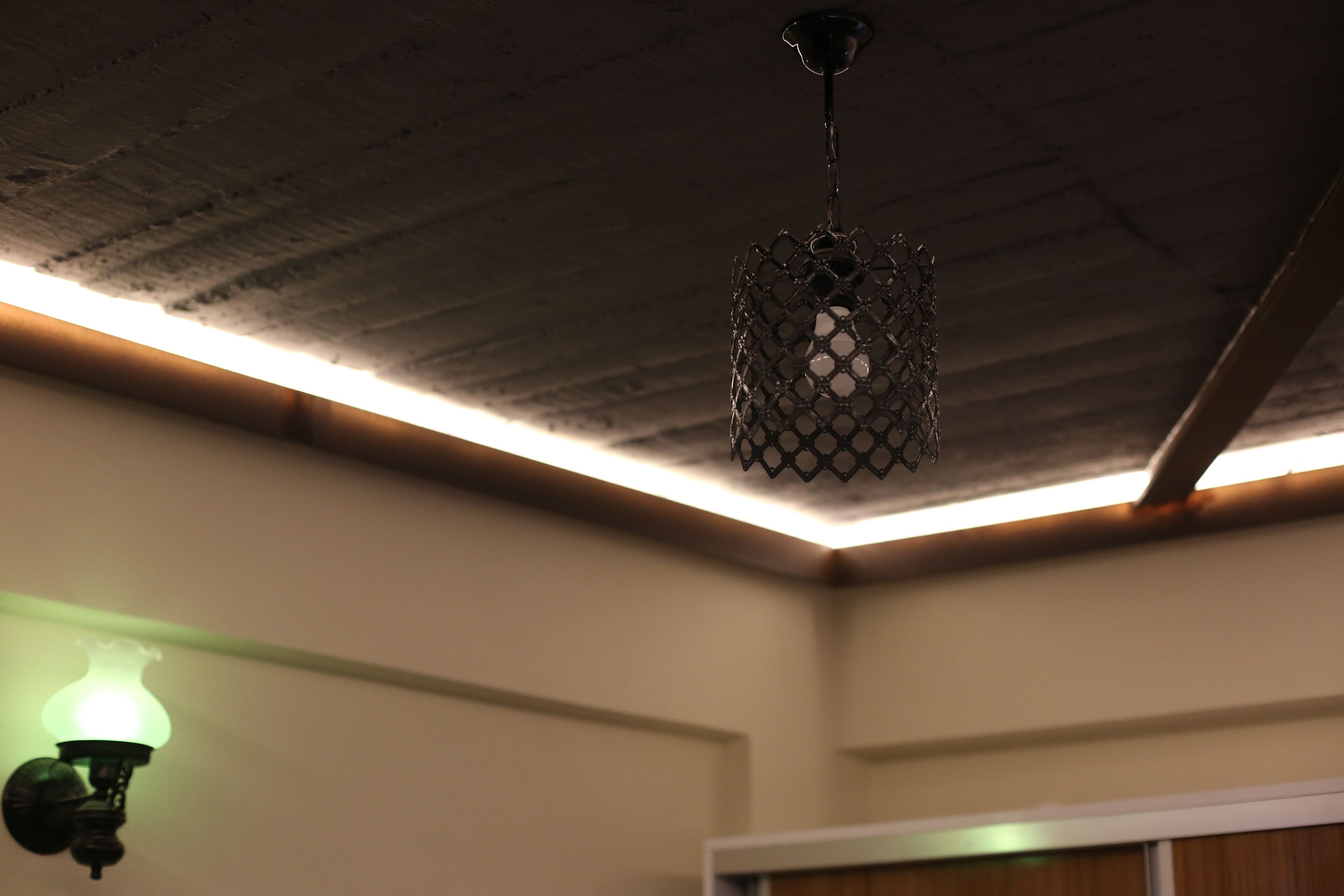 A ceiling with exposed beams and a hanging light fixture.