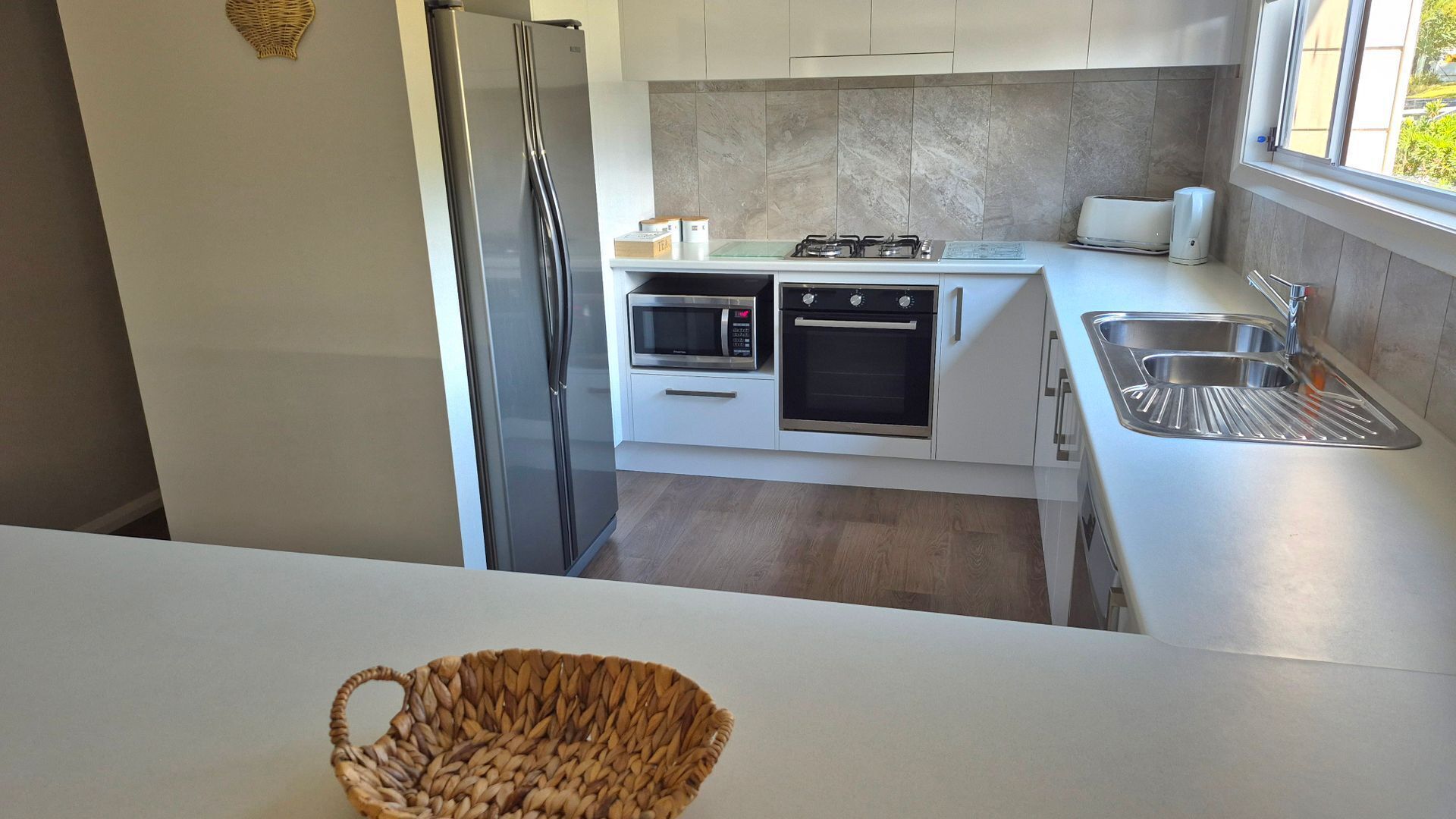 Una cocina moderna con refrigerador, microondas, horno y pileta.