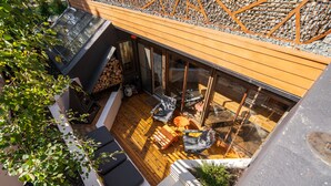 An outdoor deck with wooden flooring, a fire pit, and seating areas. - Dove's Nest | Unique Earth Home | Decks (Minneapolis)