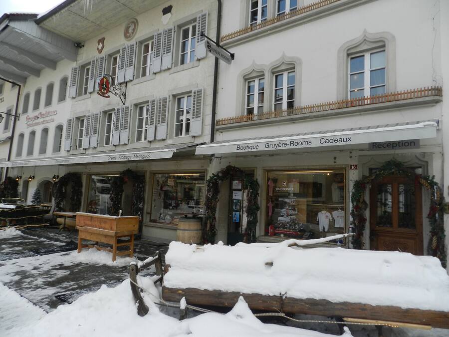 Un edificio con una boutique, Gruyère-Rooms y una zona de recepción.