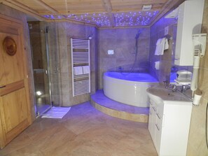 Bathroom features a bathtub, glass shower enclosure, and a white sink with a mirror.