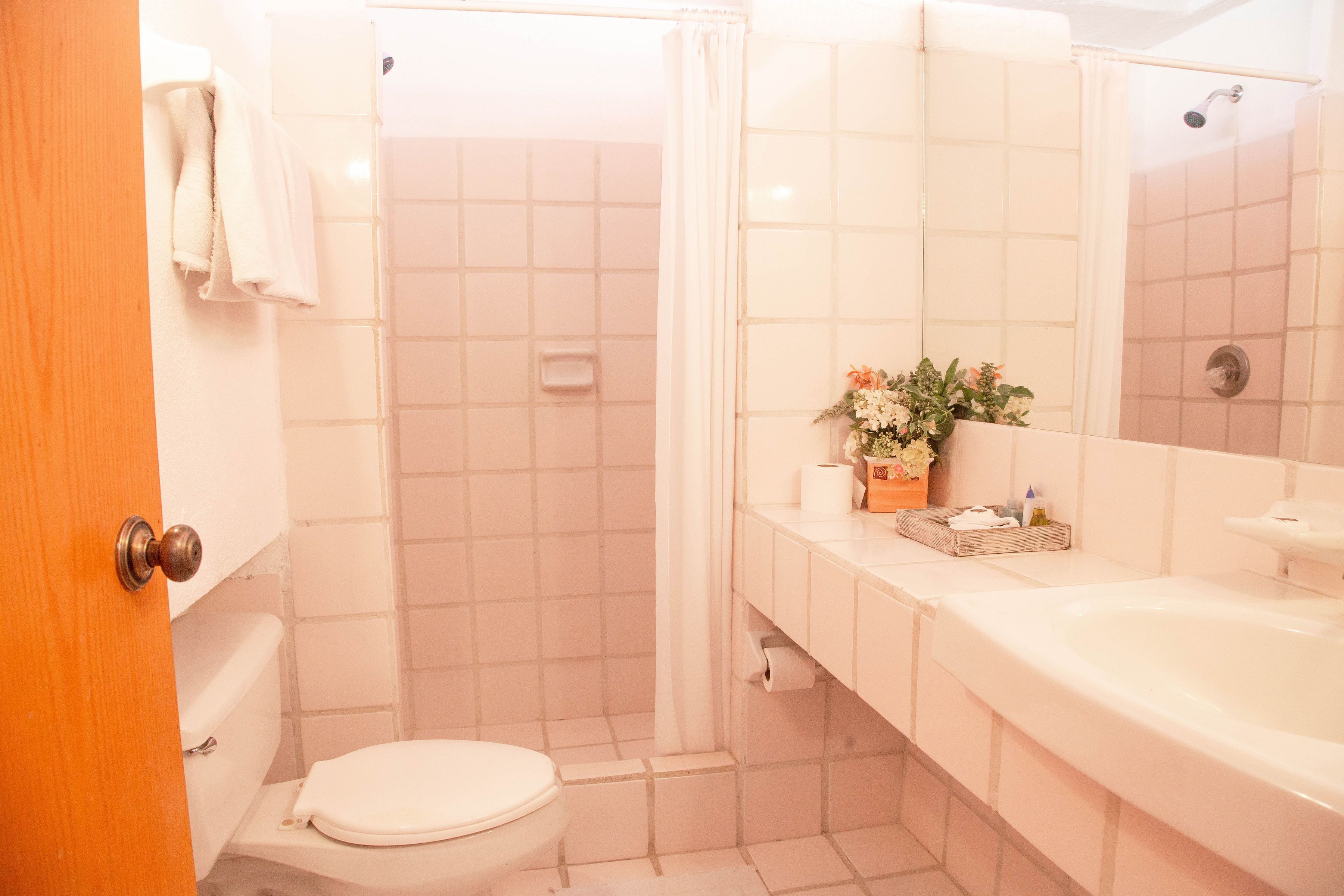 A bathroom with a toilet, shower, and sink.