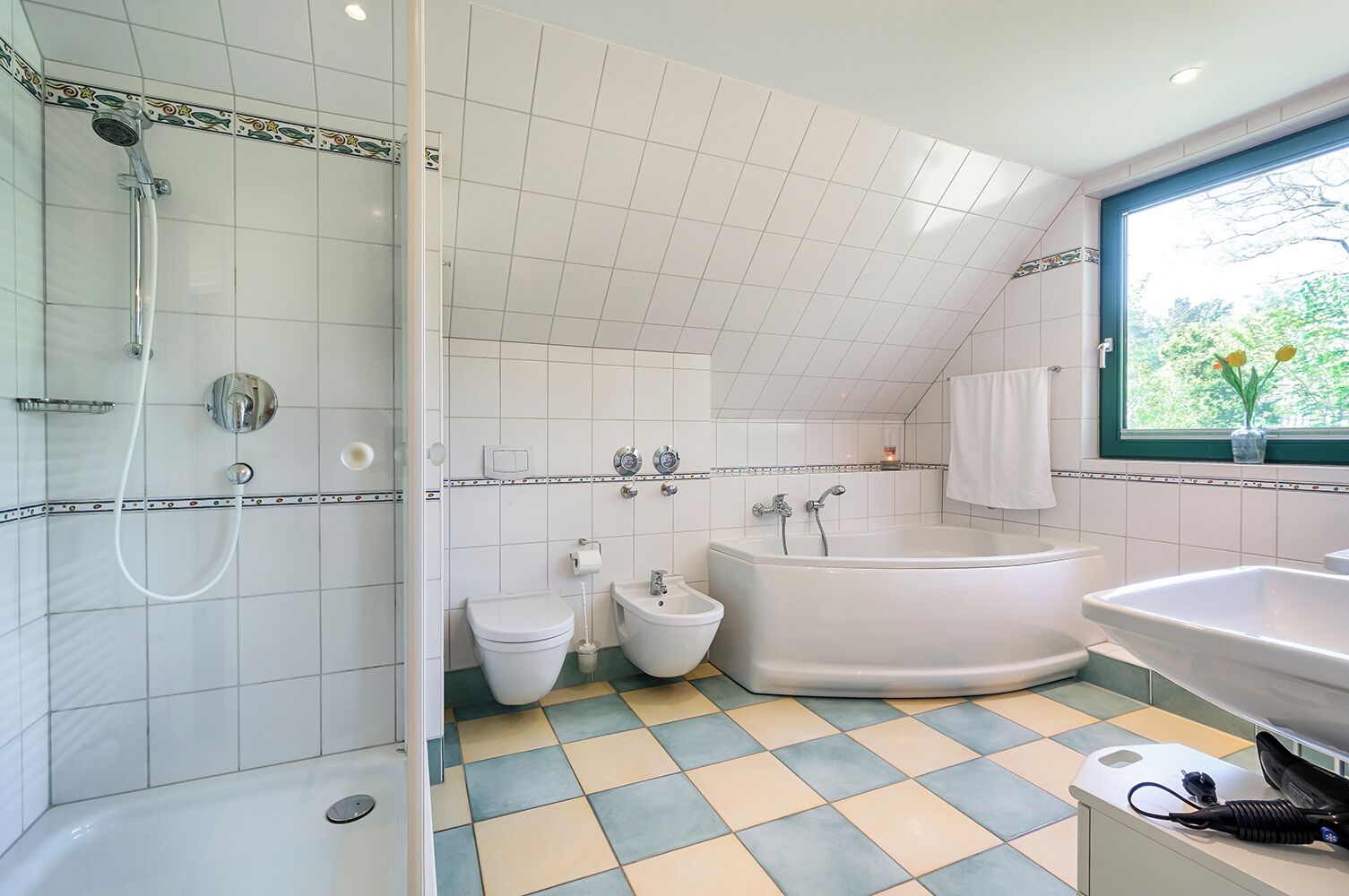 A modern bathroom with a shower, toilet, bidet, and bathtub.