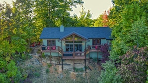 A house with a large deck, a covered front porch, and a staircase leading to the deck. - THE Smoky Mountain Views, Comfort, Style, Games  (Gatlinburg)