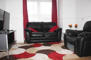 Relax in this stylish living room with a comfortable sofa, flat-screen TV, and beautiful views.