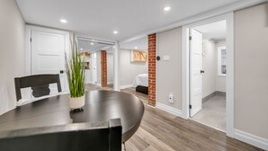Un comedor moderno con una mesa redonda, sillas y una planta en maceta.