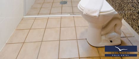 A bathroom with a glass-enclosed shower, a toilet, and a granite countertop.